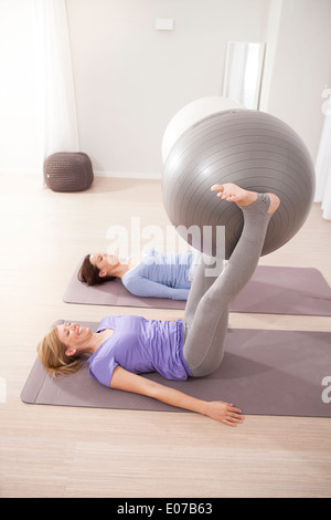 Le donne a fare pratica con palle ginniche sulla classe di Pilates Foto Stock