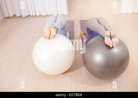 Le donne a fare pratica con palle ginniche sulla classe di Pilates Foto Stock