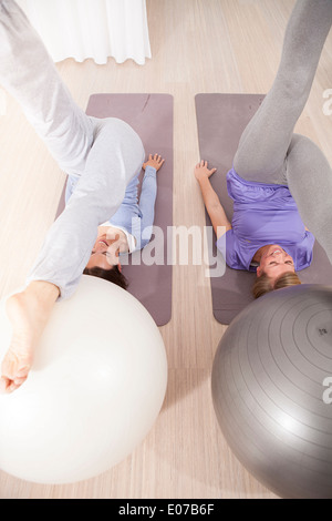 Le donne a fare pratica con palle ginniche sulla classe di Pilates Foto Stock