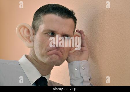 (FILE) - un'immagine di archivio, datata 27 febbraio 2011, mostra un uomo che indossa orecchie di gomma e che finge di cadere in una conversazione o un rumore mentre si appoggia contro un muro in Germania. Fotoarchiv für Zeitgeschichte ATTENZIONE - NESSUN FILO DI SERVIZIO - Foto Stock