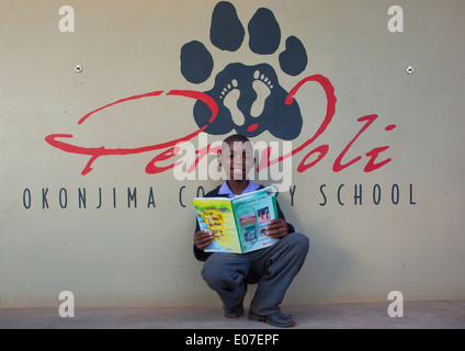 Ragazzo la lettura di un libro alla Fondazione Africat, l'Okonjima, Namibia Foto Stock