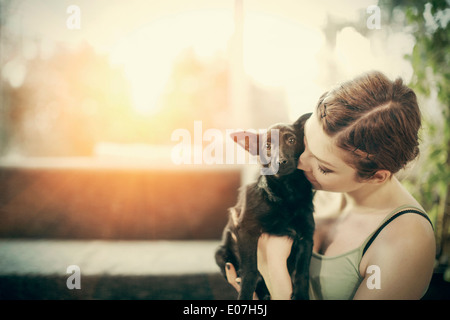 Giovane donna giocando con il cane a casa Foto Stock