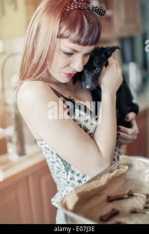 Giovane donna la cottura biscotti per il suo cane Foto Stock