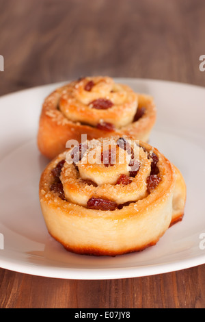 Deliziosi panini di turbolenza con uvetta e zucchero di canna su una piastra Foto Stock