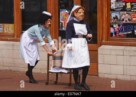 1940s ostetriche su chiamata dal teatro Vamos arrivano nella loro divise, spingendo il loro carrello e aiutando gli ignari membri del pubblico come parte di Poole Street Arts Festival sulla banchina per celebrare il giorno di maggio Banca Credito Vacanze: Carolyn Jenkins/Alamy Live News Foto Stock