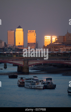 Canary Wharf Tower al tramonto dalla Waterloo bridge con il fiume Tamigi e Blackfriars Bridge in primo piano Londra Inghilterra REGNO UNITO Foto Stock