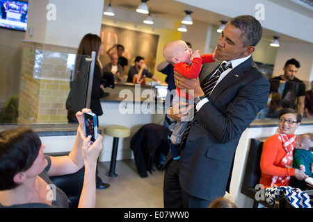 Il presidente statunitense Barack Obama gioca con un bambino mentre saluto patroni prima di pranzo presso il ristorante Coupe 10 Gennaio 2014 a Washington, DC. Foto Stock