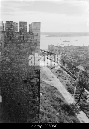 Castelo de São Jorge, situato a Lisbona, Portogallo, è un castello storico che si affaccia sulla città. Si tratta di un punto di riferimento iconico conosciuto per la sua ricca storia, che offre ai visitatori uno sguardo al passato attraverso la sua architettura e le vedute che offre su Lisbona. Foto Stock