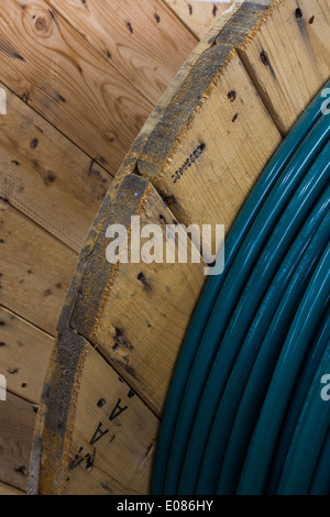 Vista parziale di cavo elettrico su un grande tamburo di legno Foto Stock