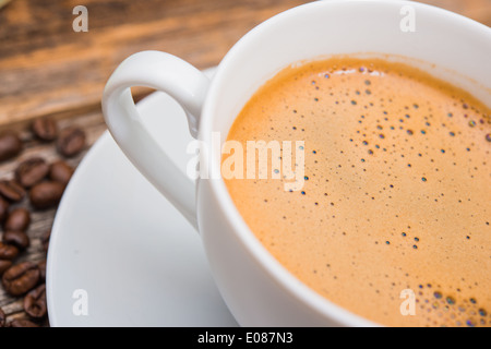 Una gustosa pausa caffè. Il caffè caldo in bianco piccola tazza da caffè Closeup. Foto Stock