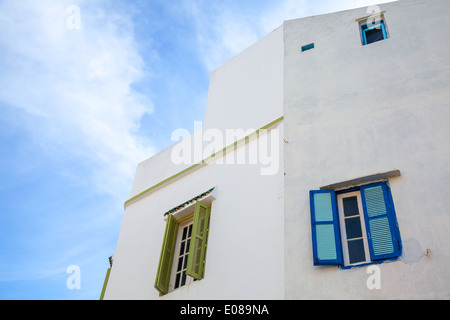 Muro Bianco con finestre e cielo blu. Medina, parte vecchia di Tangeri, Marocco Foto Stock