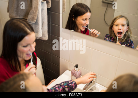 Madre e figlia spazzolare i denti in bagno Foto Stock