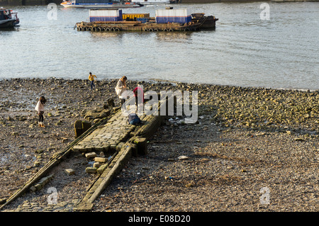 Persone in occasione di una bassa marea per esplorare un vecchio molo sul Tamigi foreshore. Foto Stock