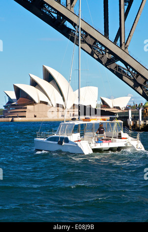 Catamarano passa sotto il Ponte del Porto di Sydney. Foto Stock