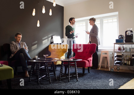 Imprenditore seduto mentre i colleghi a discutere in office Foto Stock