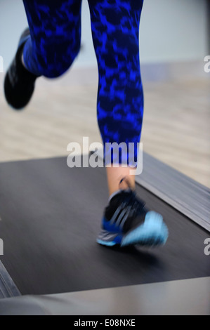 Donna in corsa su tapis roulant Foto Stock