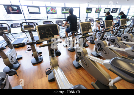 Vista posteriore di persone che lavorano sulla cyclette in palestra Foto Stock