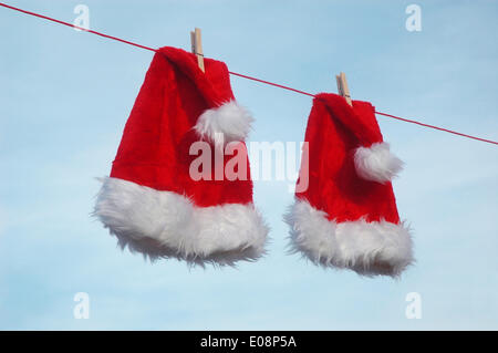 Illustrazione - due cappelli di Babbo Natale sono appesi su un vestito in Germania, 28 dicembre 2009. Fotoarchiv für Zeitgeschichte - SENZA FILI Foto Stock