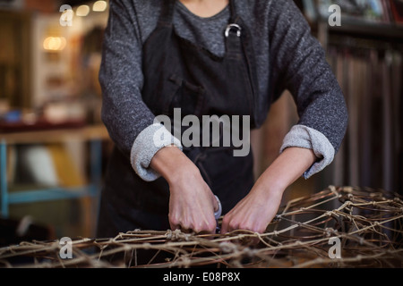 Sezione mediana del lavoratore di sesso femminile che rendendo chaise longue in officina Foto Stock