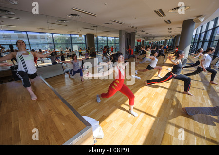 La gente lo stiramento durante lo Yoga lezione di fitness in palestra Foto Stock