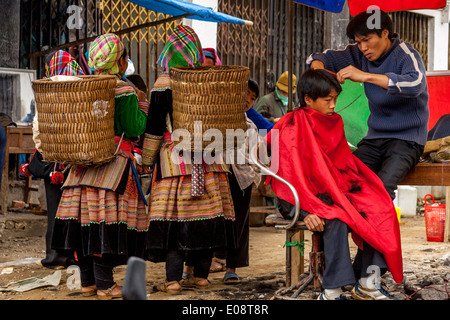 Barbiere di strada il taglio di capelli al mercato domenicale di Bac Ha, Lao Cai Provincia, Vietnam Foto Stock