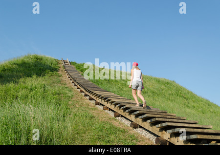 Tourist donna salire sul tumulo di colline in lituano capitale storica Kernave, Sito Patrimonio Mondiale dell'UNESCO. Foto Stock