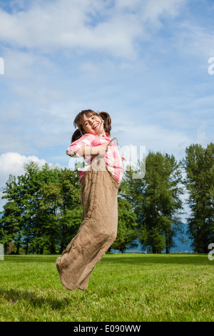 Ragazza in un sacco gunny gara Foto Stock