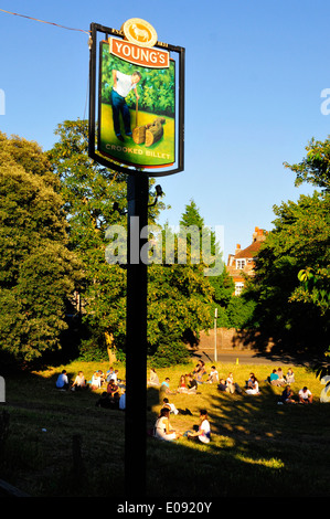 Persone bere sull'erba al di fuori della billetta storte pub, Wimbledon Village, Wimbledon, Londra Foto Stock