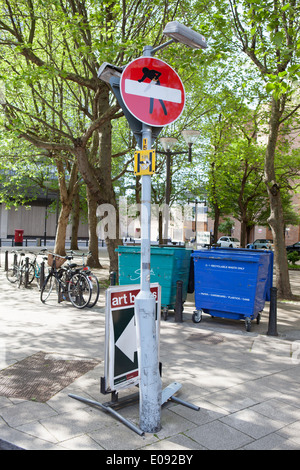 Clet Abraham mette adesivi su cartelli stradali per alterare il loro significato. Foto Stock