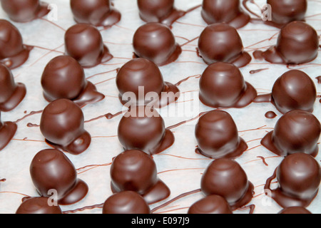 Mano immersa cioccolato al latte Foto Stock