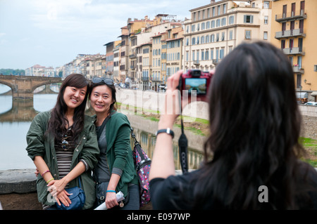 Giovani donne asiatiche fotografare ogni altro su Il Ponte Vecchio Ponte Vecchio di Firenze Italia Foto Stock