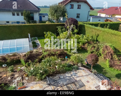 Un giardiniere ri-modifica un Thuje. Le opere in giardino., Ein Gaertner schneidet eine Thuje um. Arbeiten im Garten. Foto Stock