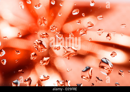 Rosso sfondo astratto con gocce d'acqua su vetro con nastro in background Foto Stock