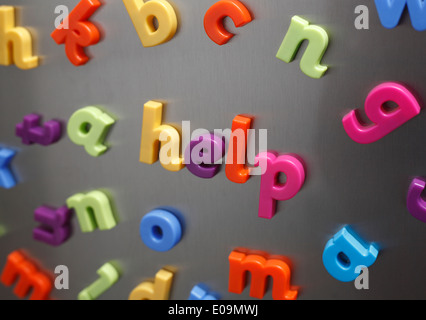 'Help' enunciato in plastica lettere magnetiche su un frigo. Foto Stock