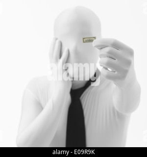 Preoccupati sconosciuto persona vestita in abito bianco con black tie tenendo un piccolo dollaro Foto Stock