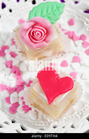 Due petit four e decor di cottura sulla torta stand Foto Stock