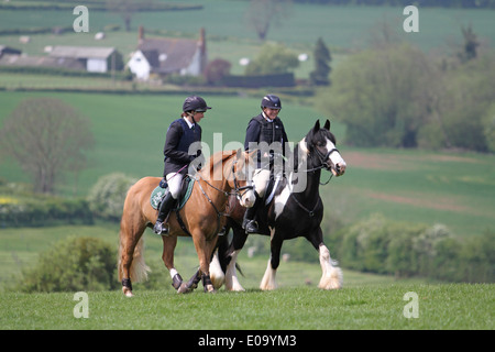 Due cavalli e cavalieri godendo di una passeggiata attraverso la campagna Foto Stock