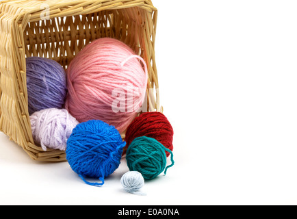 I fili colorati che rientrano al di fuori del cestello, isolato su sfondo bianco con spazio di copia Foto Stock