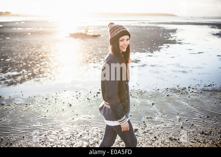 Giovane donna fuori per passeggiare sulla spiaggia Foto Stock