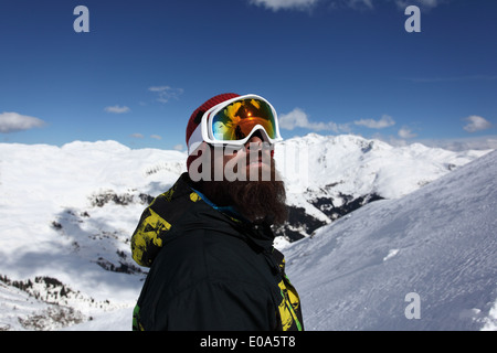 Metà uomo adulto sciatore cercando fino alla montagna, Mayrhofen, Tirolo, Austria Foto Stock