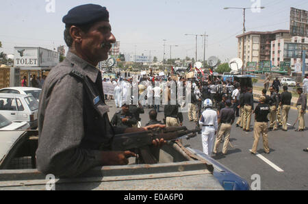 Karachi, Pakistan, 07th maggio, 2014. I funzionari di polizia sono avviso permanente per disperdere il rally di insegnanti sottopagati spostandosi in avanti verso casa Bilawal come stanno protestando contro per i loro stipendi che sono in attesa per gli ultimi venti mesi, durante una manifestazione svoltasi sotto l'ombrello di insegnanti Commissione di azione, a Karachi il Mercoledì, Maggio 07, 2014. Credito: S.Imran Ali PPI/images/Alamy Live News Foto Stock