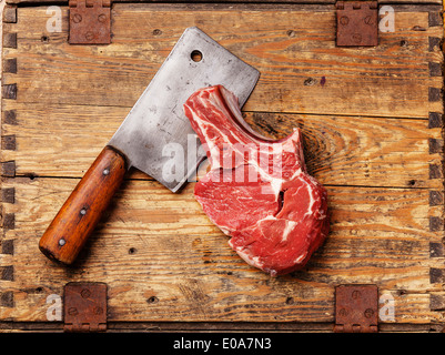 Materie carne fresca e cleaver su sfondo di legno Foto Stock