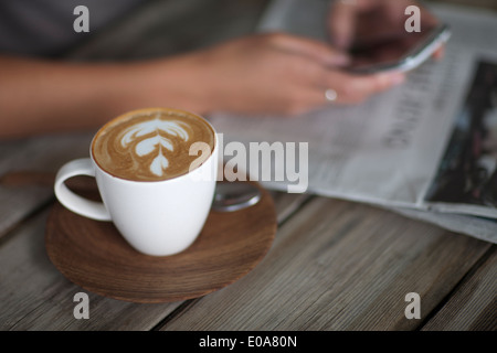 Close up della giovane donna tramite cellulare in cafe Foto Stock