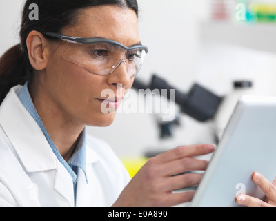 Scienziato di visualizzazione dei risultati di prova su una tavoletta digitale in laboratorio Foto Stock