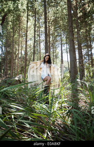 Giovane donna camminare attraverso la foresta Foto Stock