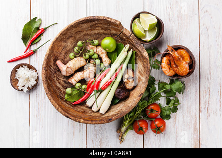 Ingredienti per piccante zuppa tailandese Tom Yam con latte di cocco, peperoncino e frutti di mare in bianco sullo sfondo di legno Foto Stock