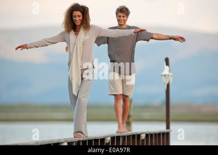 Coppia giovane equilibratura su jetty Foto Stock