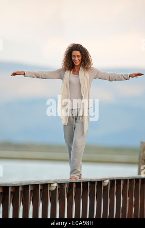 Giovane donna in equilibrio su jetty Foto Stock