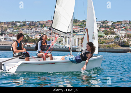 Tre giovani amici vela in porto Foto Stock