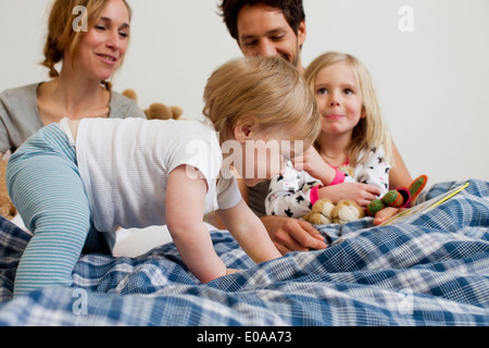 Un anno di età Baby girl strisciando sul letto dei genitori Foto Stock